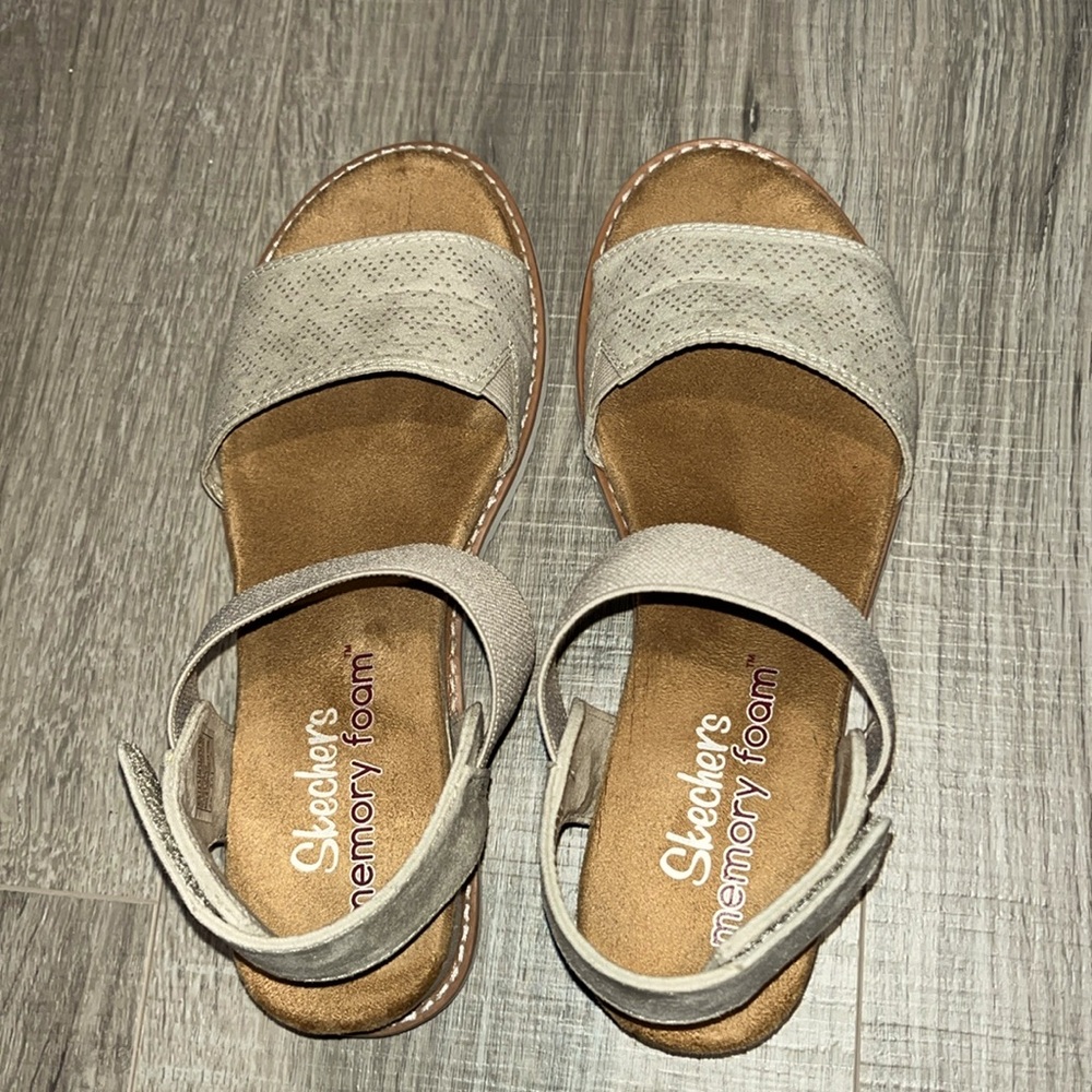 Skechers sandals in an off white to light beige color with a Velcro closure.